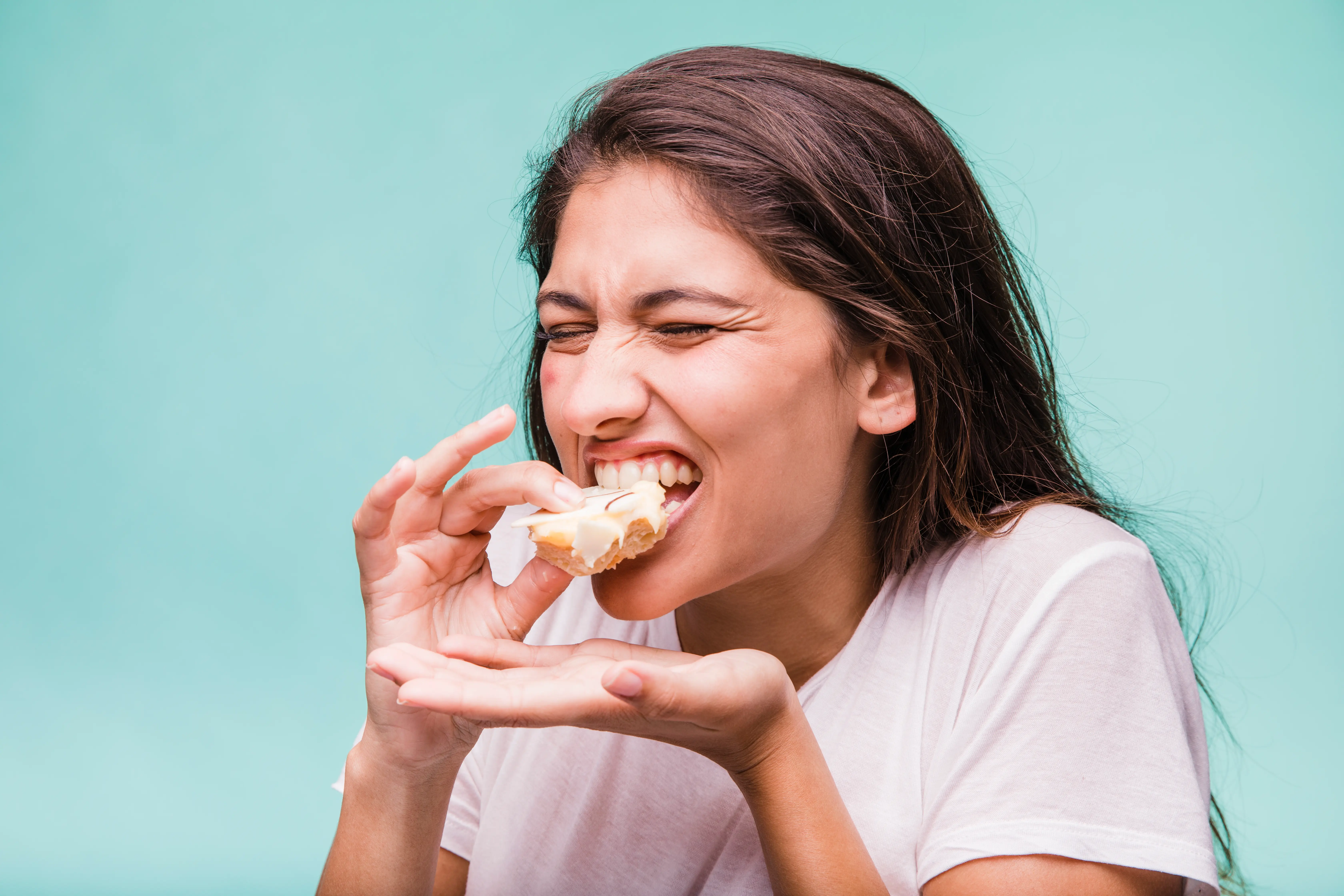 Woman feeling tooth pain while eating sweets without cavities